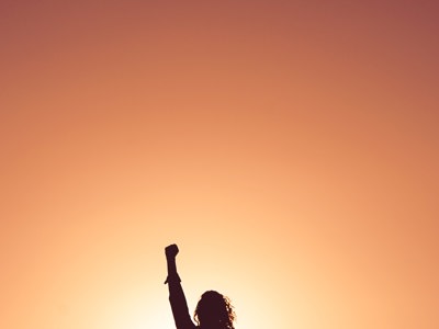 person with hand raised in air - resilient pose