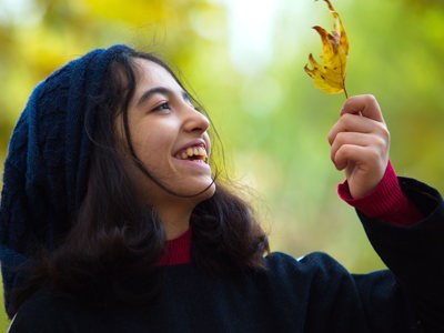 person smiling holding leave outdoors